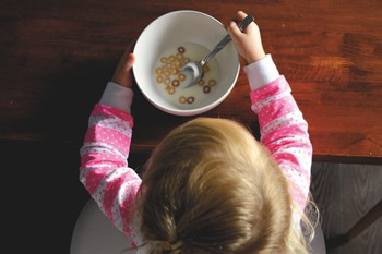 Young girl eating breakfast cereal
