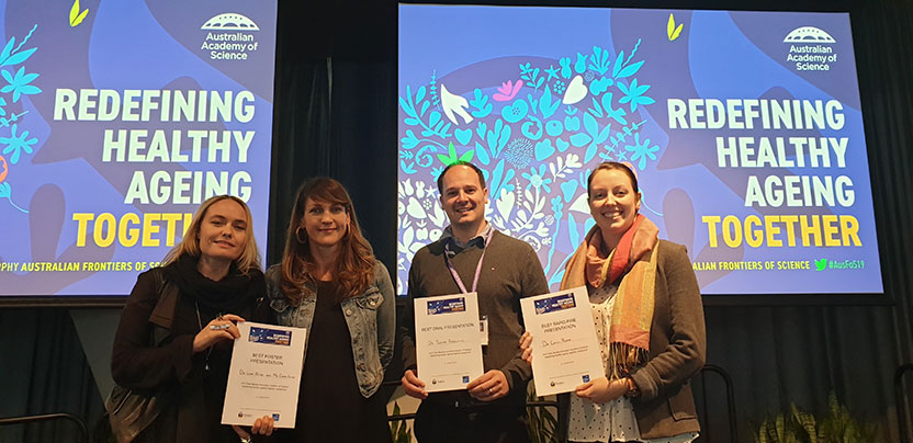 People holding certificates on stage