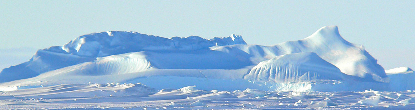 Pale blue ice- and snow-covered mountains under a blue sky