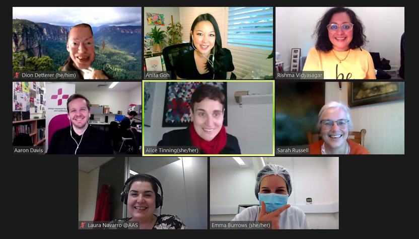 Eight smiling people in an online zoom-type meeting