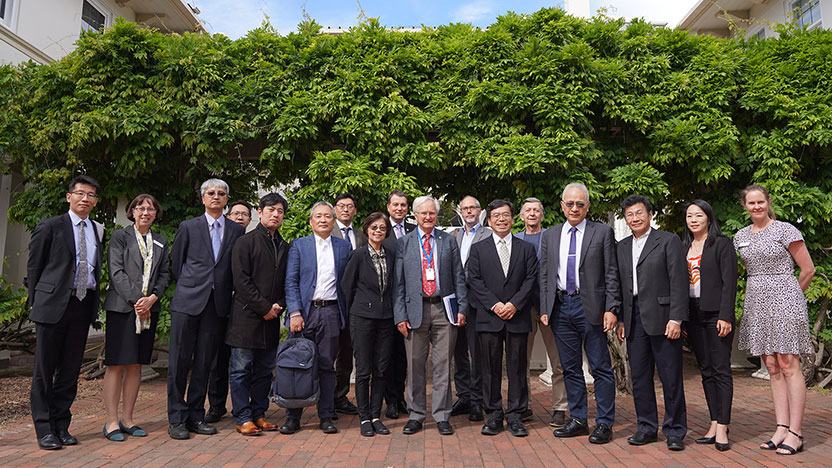 People gathered for a group photo in the leafy courtyard of Ian Potter House.