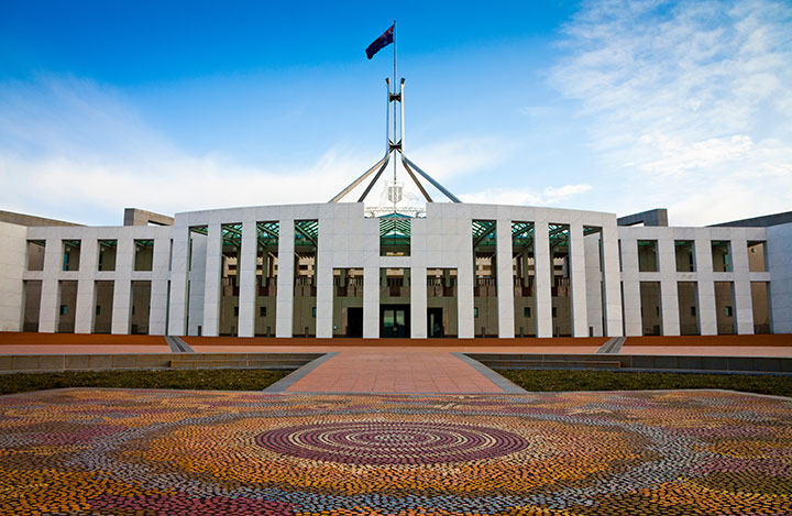 Parliament House in Canberra as viewed from the forecourt with a blue sky