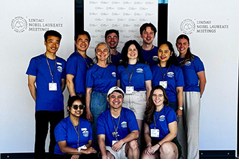A group of people stand in front of pull-up banners at the meeting